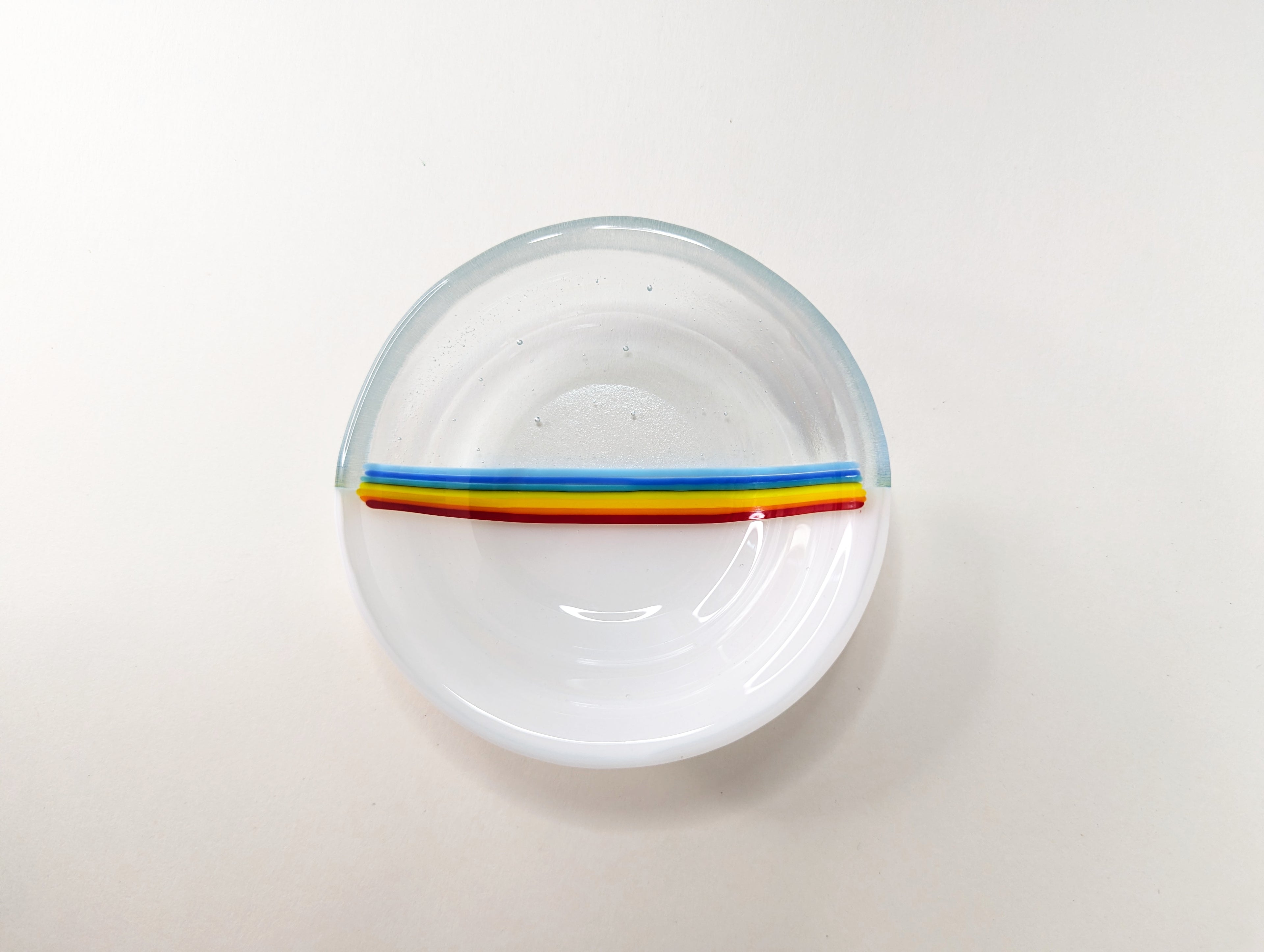 top view of white and clear dish with rainbow stripes in middle